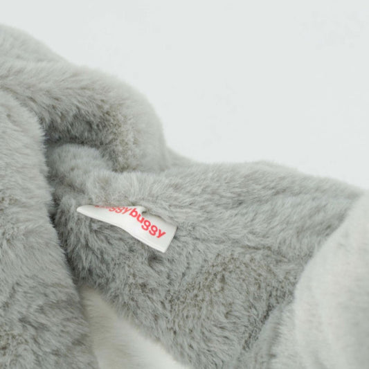 Gray fluffy elephant with a visible brand tag on a light gray background