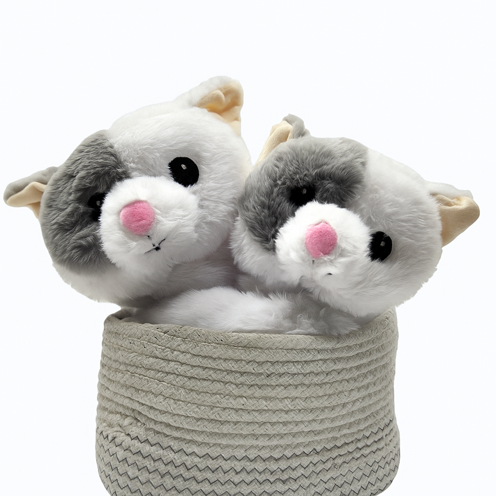Two plush cat toys in a woven basket on a white background