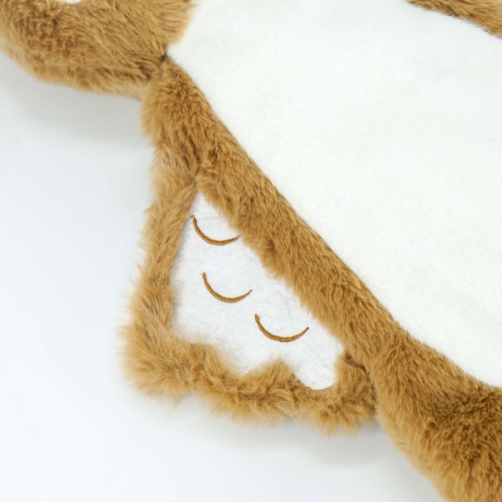 Close-up of a plush toy with brown fur and white accents on a white background