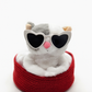 Plush toy resembling a cat wearing heart-shaped sunglasses and a red basket on a white background