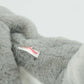 Gray fluffy elephant with a visible brand tag on a light gray background