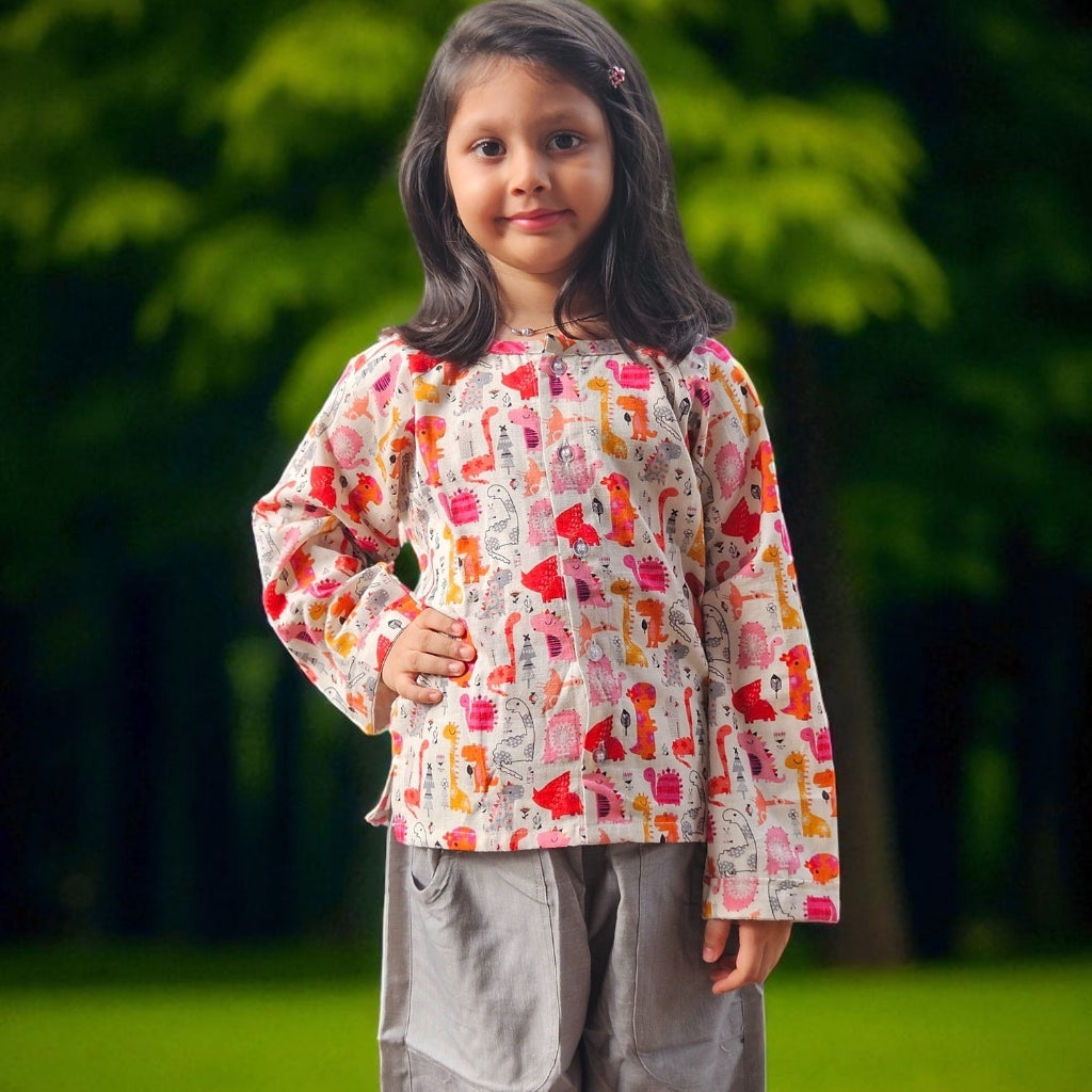 Young girl wearing a colorful patterned shirt with a blurred green background