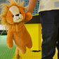 Plush lion toy held by a person with a colorful background