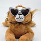 Plush lion toy wearing heart-shaped sunglasses on a white background