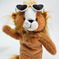 Plush lion toy wearing heart-shaped sunglasses on a white background