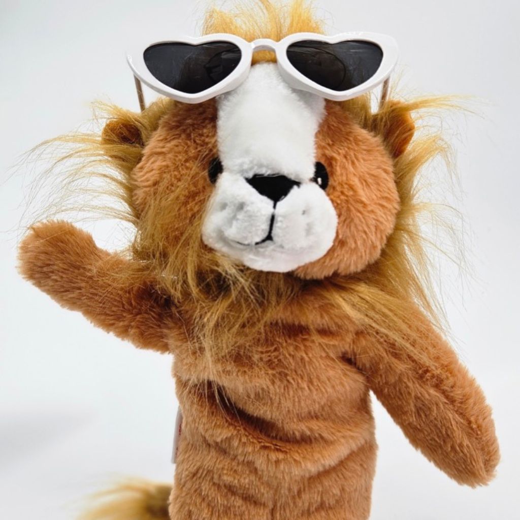 Plush lion toy wearing heart-shaped sunglasses on a white background