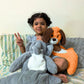 SnuggyBuggy's Coco the Dog, a soft and huggable brown and white plush toy, shown being cuddled by a happy child alongside a plush elephant